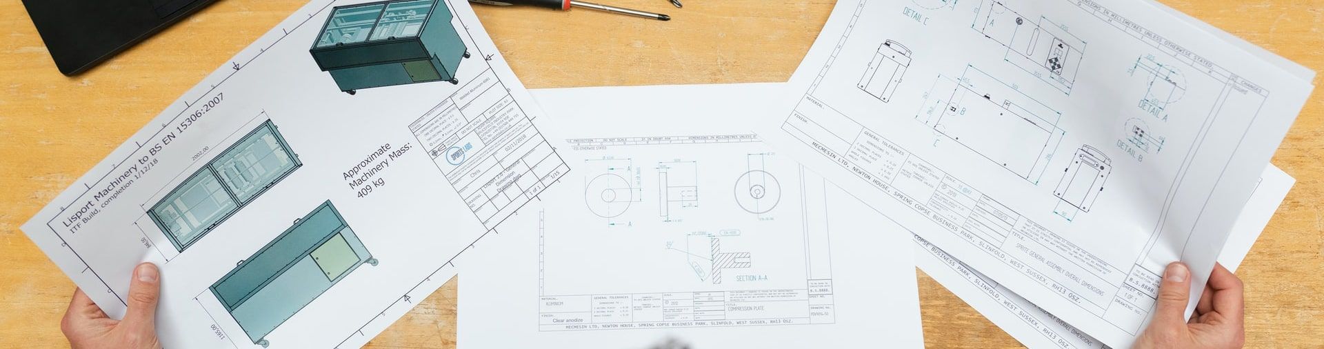 Engineer in a hard hat reviewing drawings on a large monitor